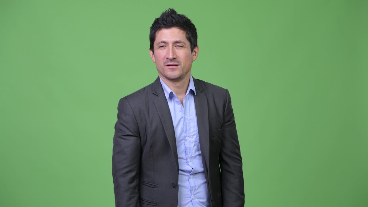 Happy Hispanic businessman giving thumbs up