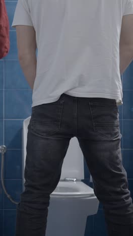 man urinating in a bathroom