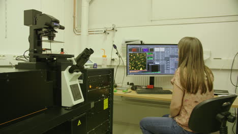 woman researcher working in a laboratory with microscope. france