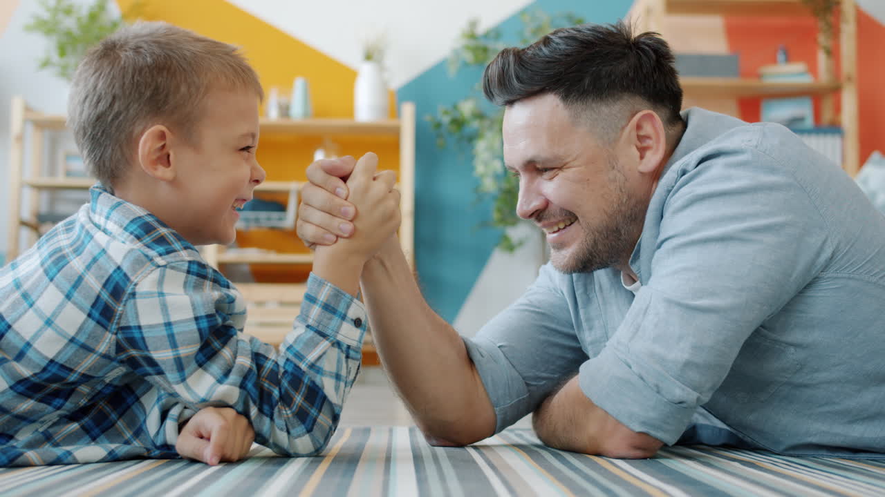 Father and son arm wrestling at home