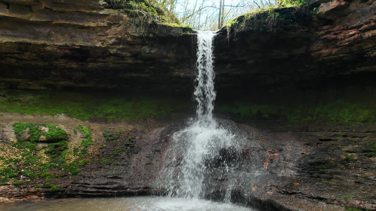 Drone view of cascade waterfall in Saharna Monastery, Moldova. Forest and cave. Slow motion