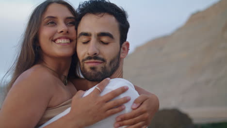 lovely couple embracing at cloudy beach closeup. happy sweethearts enjoying