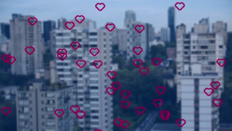 animation of multiple red heart icons floating against aerial view of tall buildings