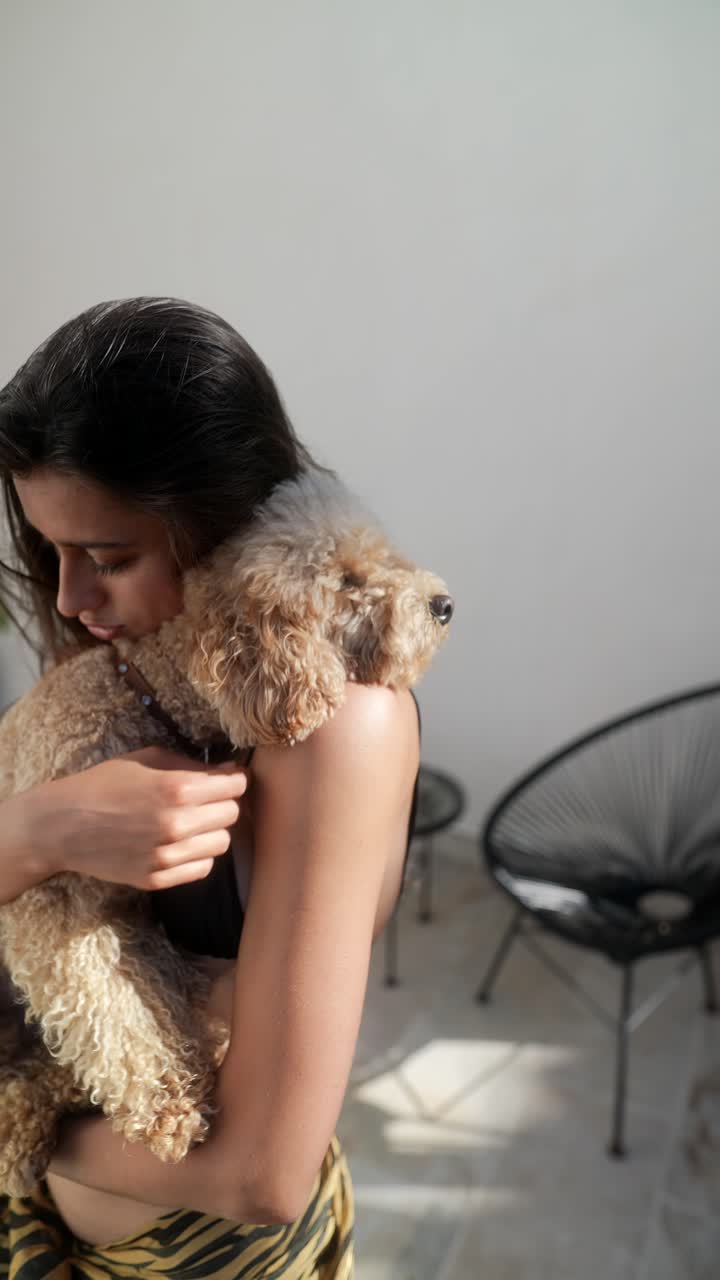 una mujer acurrucando a un caniche.