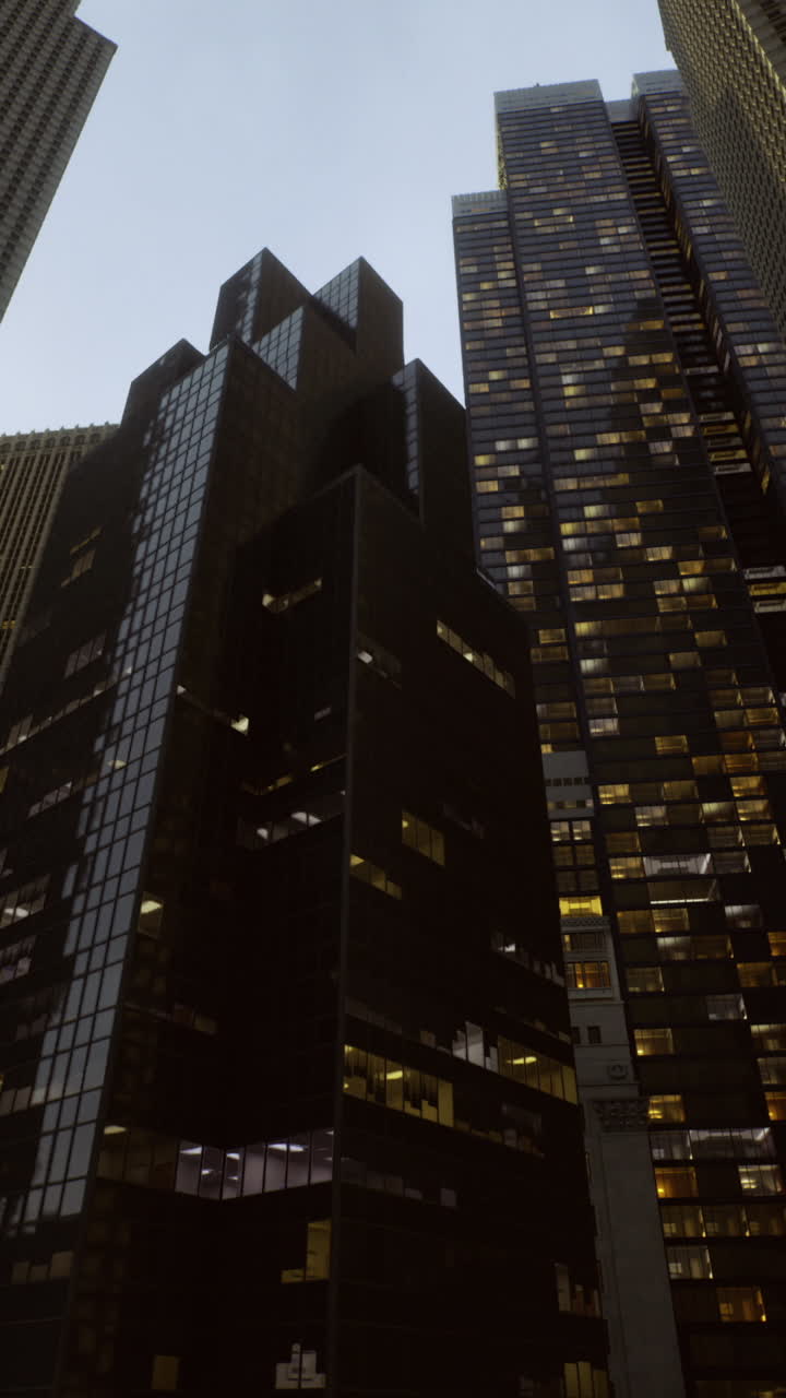 Skyward view of modern skyscrapers in an urban setting at dusk