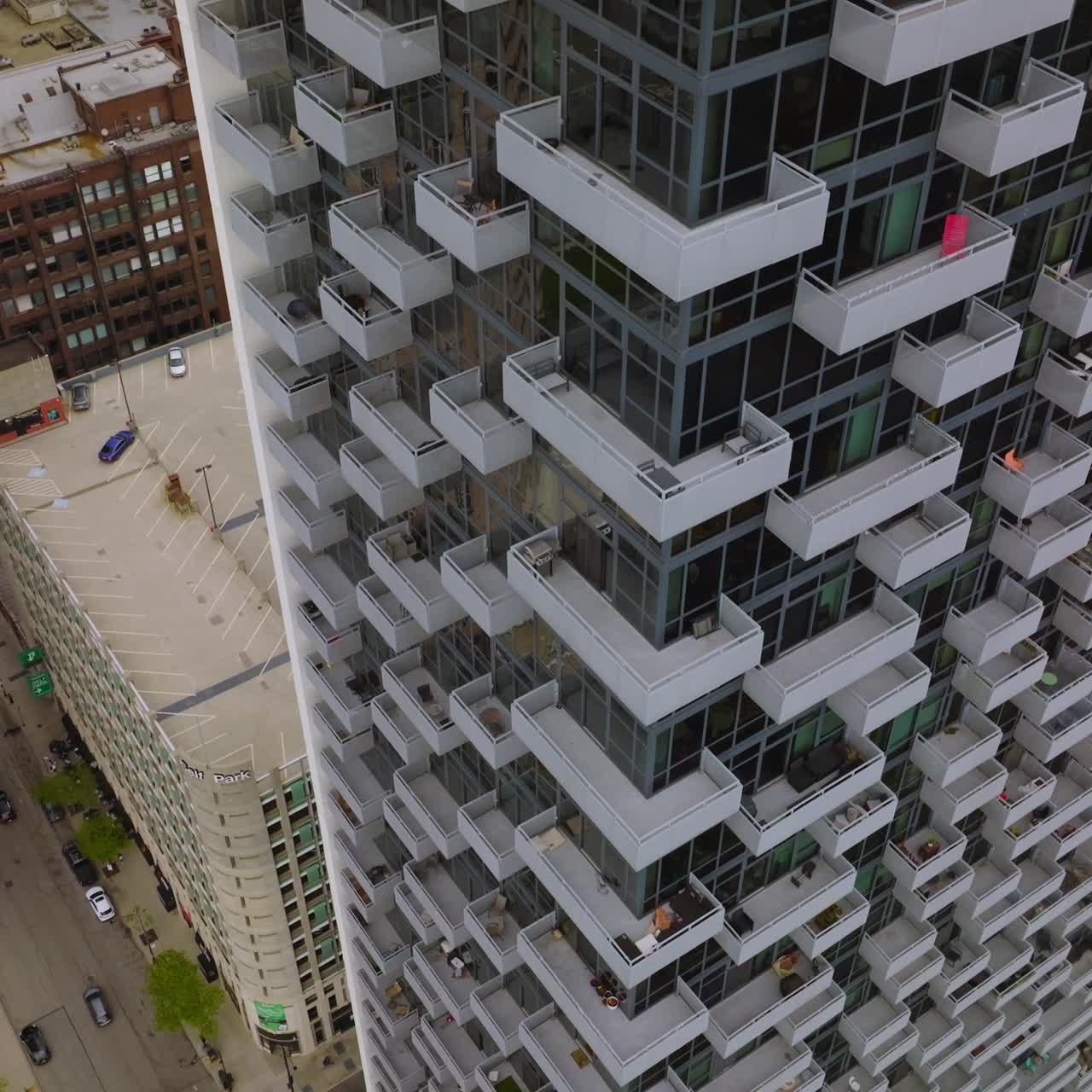 Peeping at the balconies of beautiful multi-storied building of Chicago. Drone footage descending along the house
