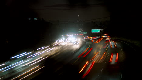 lapso de tiempo del tráfico de la autopista ocupado con desenfoque de movimiento en los ángeles por la noche