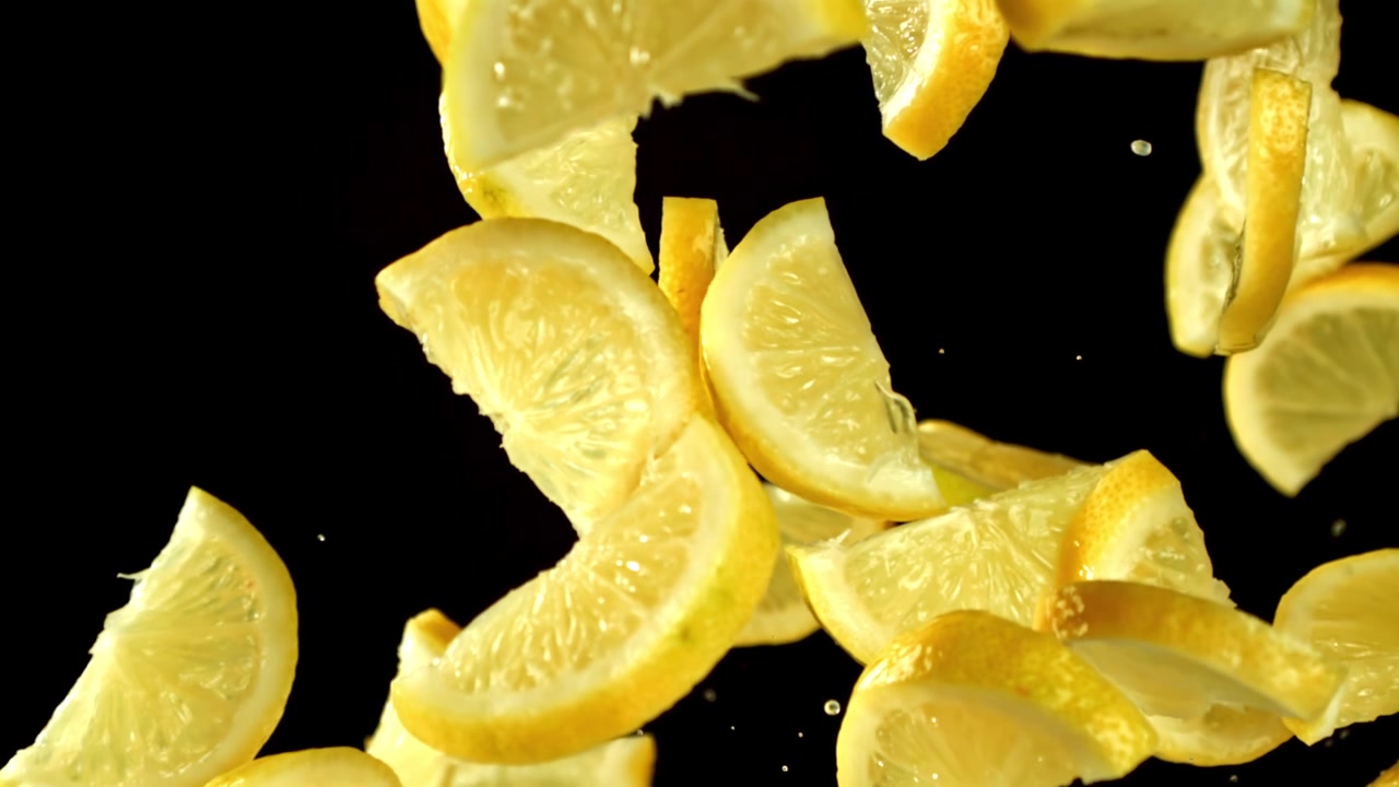 Fresh Lemon Slices Falling and Rising in Slow Motion