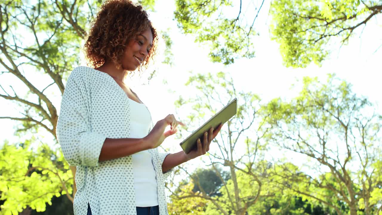 Donna che utilizza compressa digitale nel parco