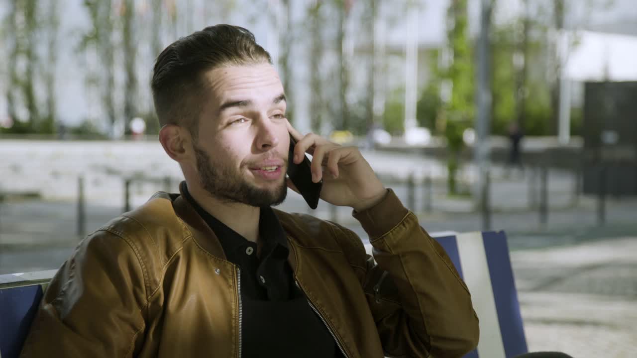 공원에서 스마트폰으로 이야기하는  ⁇ 수염을 가진 쾌활한 남자.