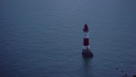 Red-and-White-Lighthouse-with-Flashing-Light-After-Dusk