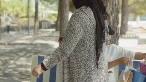 muslim man sitting on bench, meeting wife after shopping.