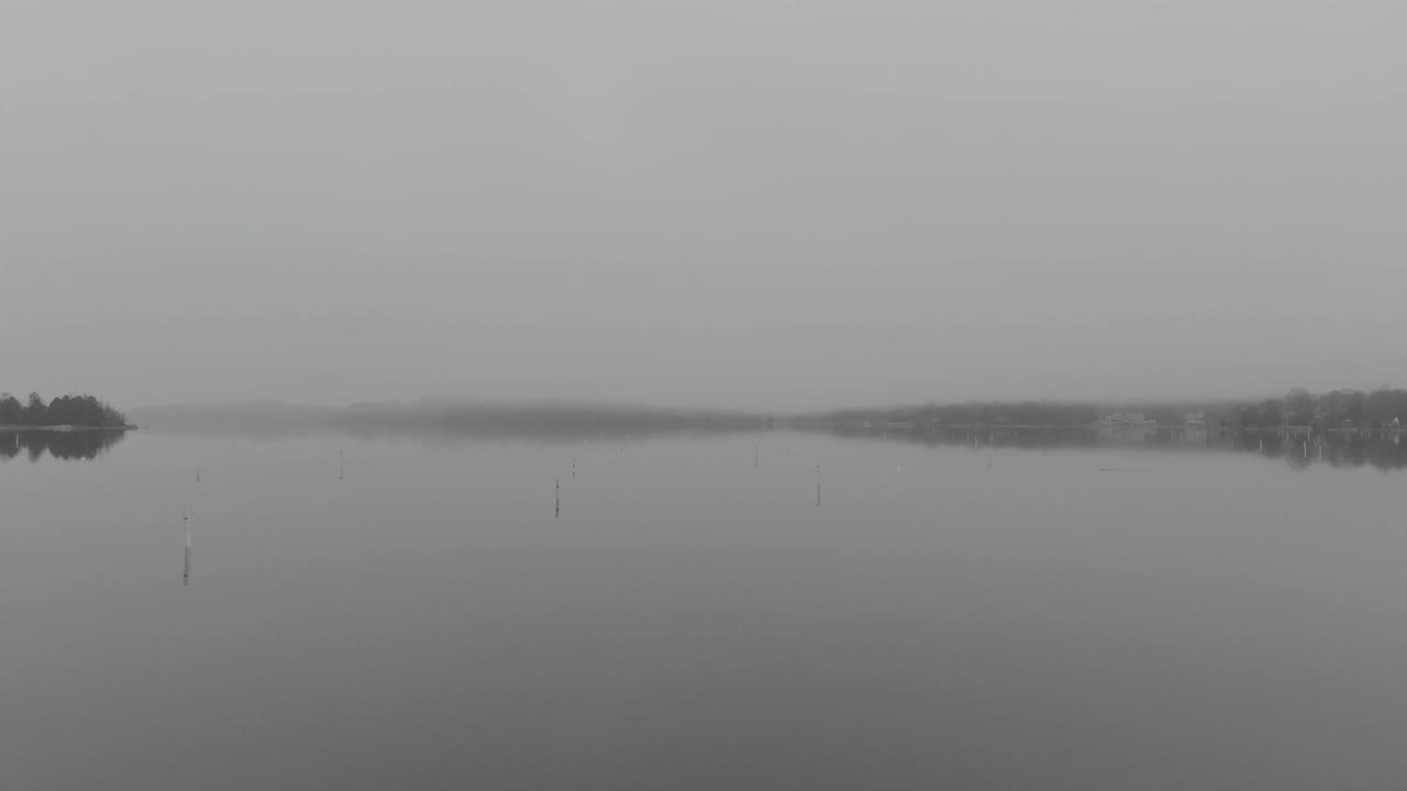 무인기 가 보이지 않는 안개 로 된 항구 를 날아다니며 해안 에 부이 를 놓고 있다