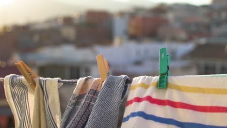 clothes hanging by clothespins on a sunset with the city in the background blurred