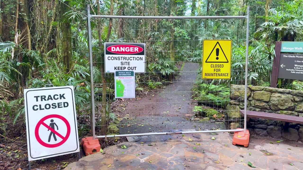 A rainforest walking track is closed due to construction and maintenance, with warning signage displayed