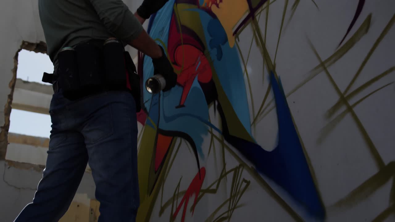 artista de graffiti mirando la pared en el sol 4k
