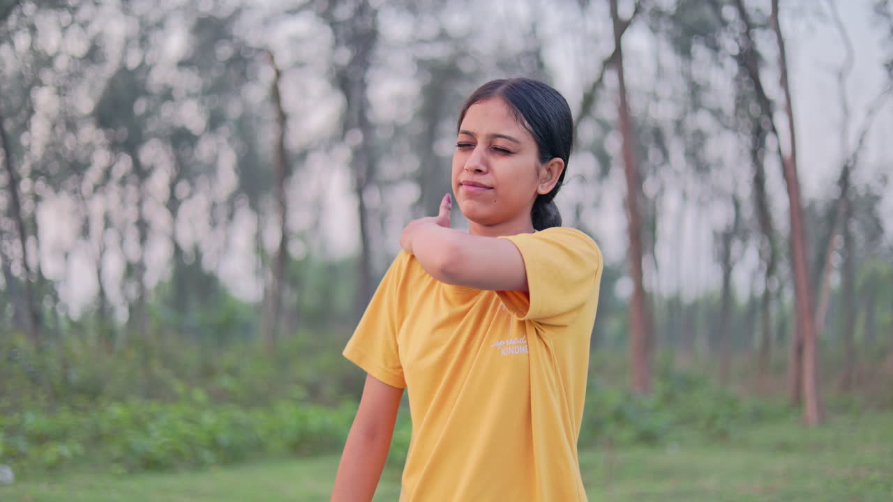 Medium shot of a woman suffering from shoulder pain, massaging the painful area at outdoor