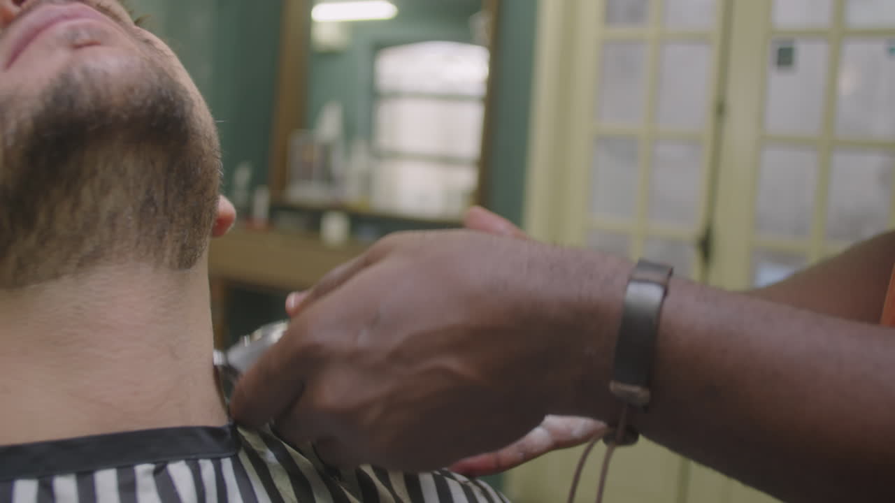Barber Shaving Beard of Client with Electric Razor