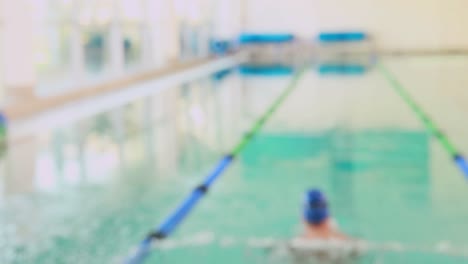 fit swimmer smiling up at camera by the pool