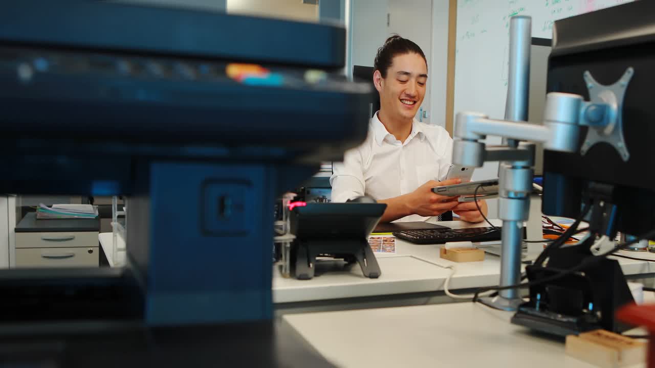 diseñador gráfico masculino usando teléfono móvil en el escritorio