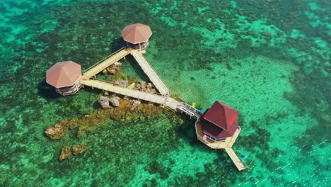 cottages connected by boardwalk at tagbak marine park on a sunny summer day in the philippines