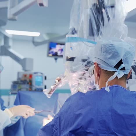 surgical procedure with microscope. group of medical specialists in blue uniform look into the microscope while doing an operation. modern medical equipment.