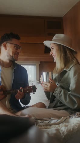 couple enjoying coffee and music in camper van