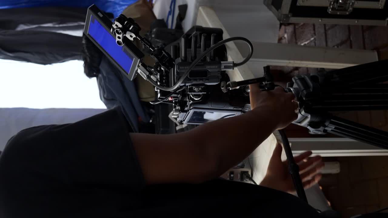 el operador de la cámara está realizando pruebas en el equipo de la cámara en preparación para un rodaje de película comercial - toma vertical