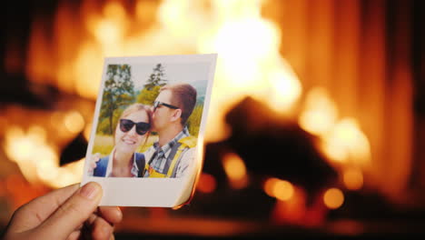 a man burns a photo of a couple in love and throws it into the fireplace