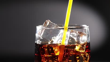 Cola-Und-Trinkschlauch-Mit-Eis-Und-Blasen-Im-Glas.