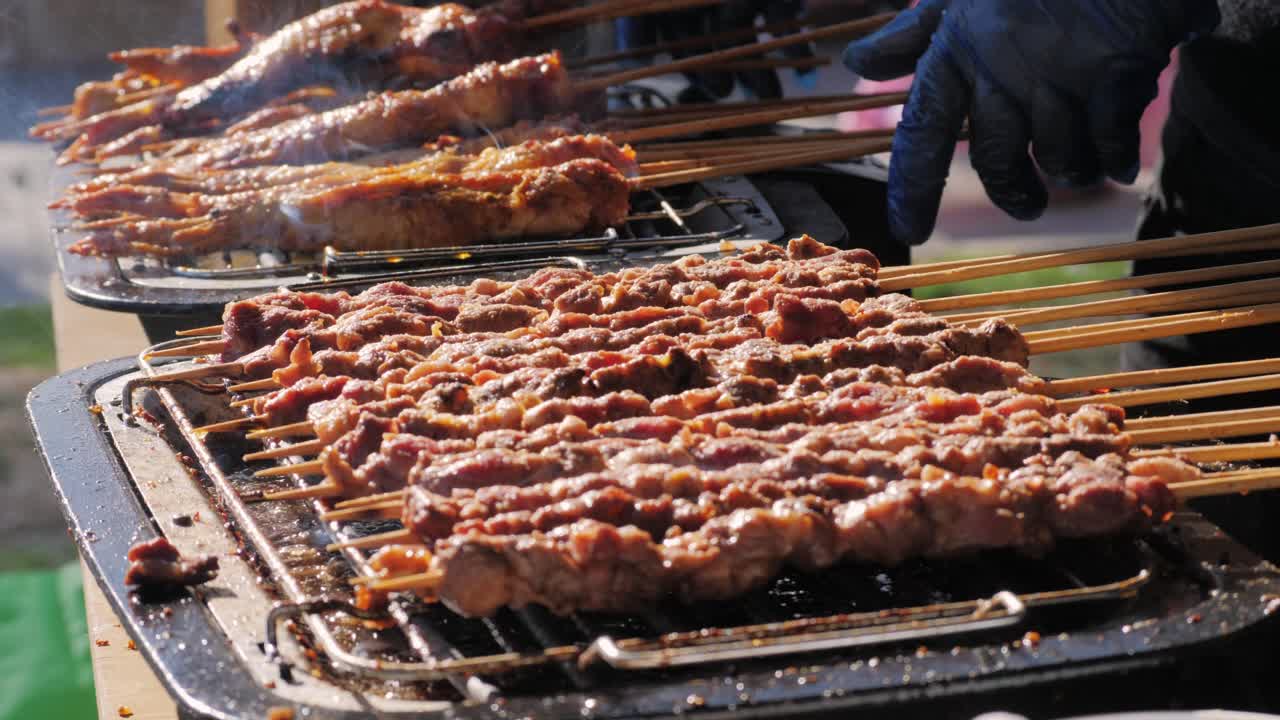 Pork meat skewer on fire, Mutton barbecue close-up. Fried meat for kebab. Cooking grilled meat beef chicken lamb BBQ . Kebab on grill. Chinese street local market with traditional food. Asian fast food.
