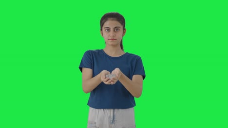 chica adolescente india con muchas monedas pantalla verde