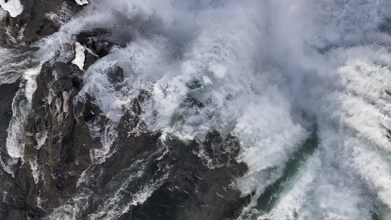 Top-down aerial view of intricate water patterns and slopes in a river near Selfoss, Iceland. Abstract natural fluid art.