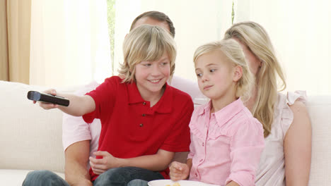 Familie-Auf-Dem-Sofa-Vor-Dem-Fernseher-Und-Chips-Essend