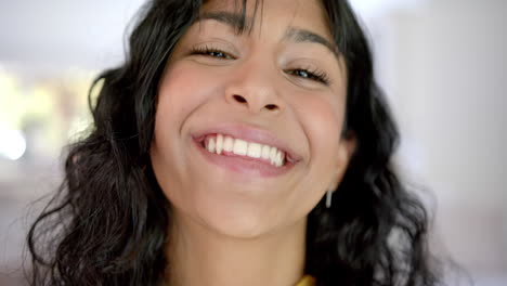 Portrait-of-happy-biracial-female-teenager-with-long-hair-at-home,-slow-motion