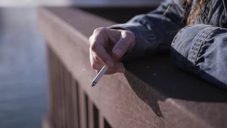 vermoeide, dakloze vrouw gooit de as op haar sigaret