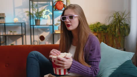 Mujer-Bonita-Sentada-En-Un-Sofá-Comiendo-Palomitas-De-Maíz,-Viendo-Una-Serie-De-Televisión-Interesante,-Un-Juego-Deportivo-En-Línea-En-Casa