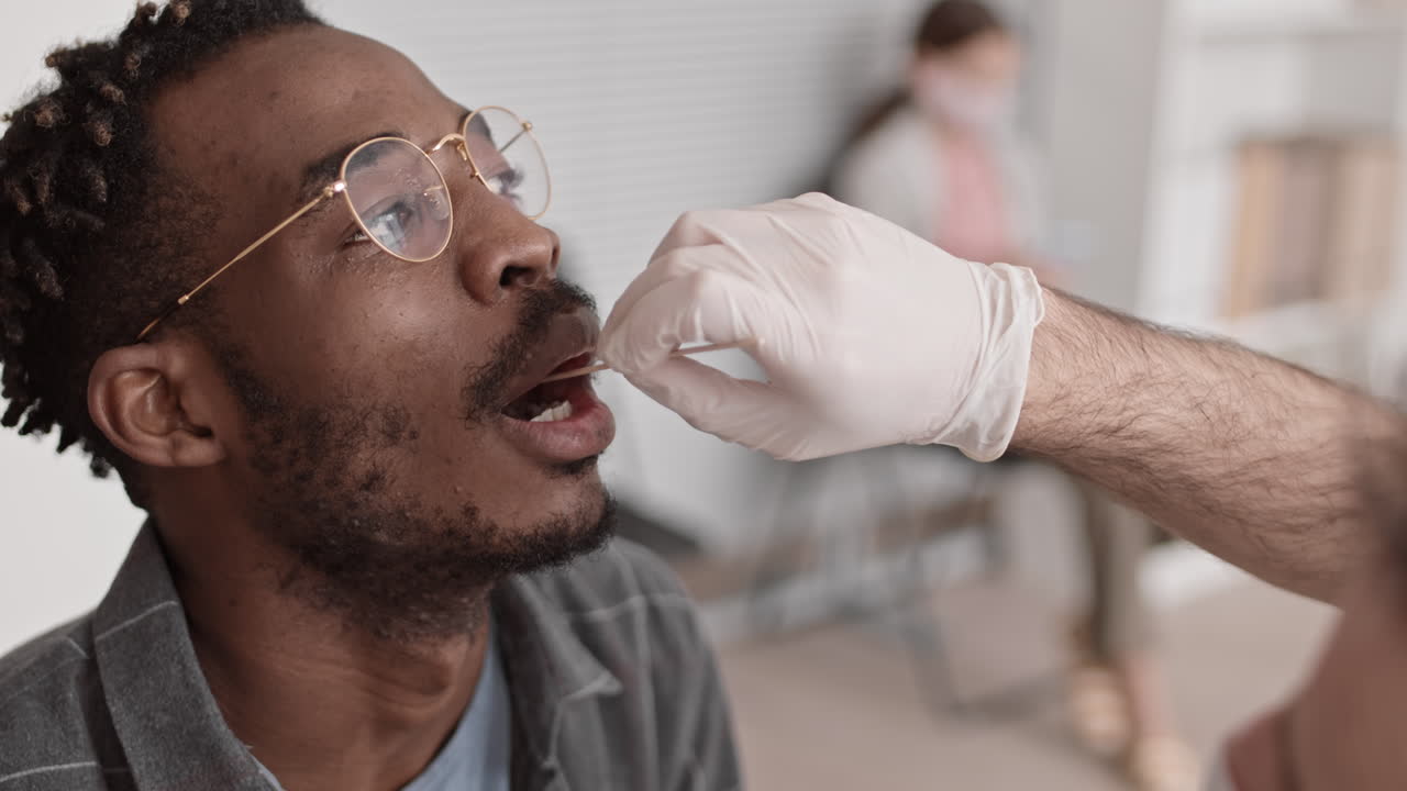 Taking Saliva Sample from Black Man