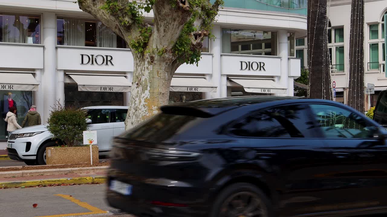 Dior Luxury Boutique In Cannes, France, With Street Traffic In Foreground. wide shot