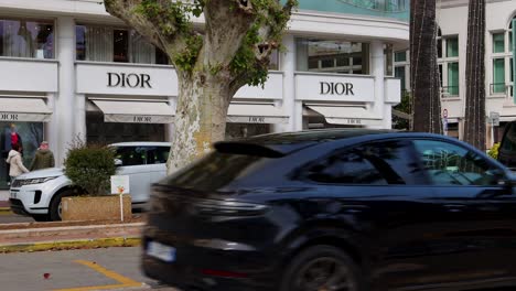 dior luxury boutique in cannes, france, with street traffic in foreground. wide shot