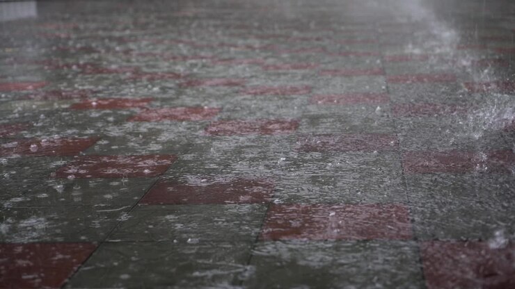 Heavy rain on a city street. Great summer downpour. Large drops fall on the asphalt.