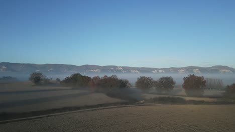 extensive cultivated fields seen from the air, covered in fog in the surroundings of taradell, vic, barcelona