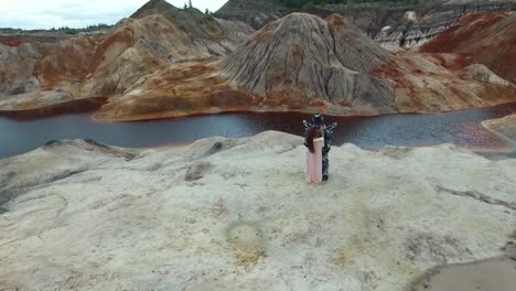 mujer en un vestido y casco de motocicleta posando en un paisaje de cantera