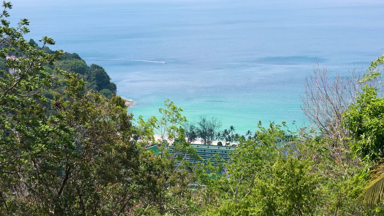 A serene view of Phuket's coastline from a lush hillside, captured in daylight with gentle camera movement