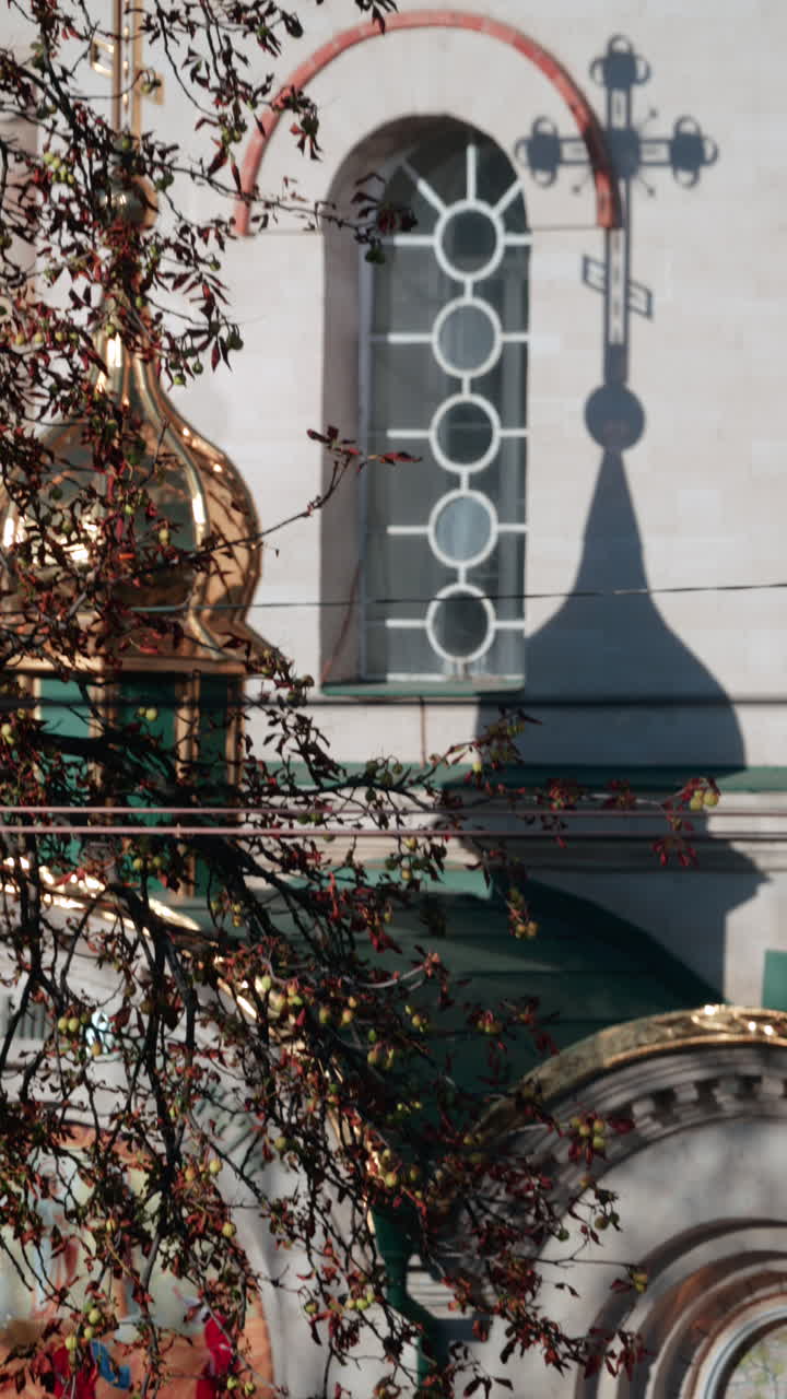 Beautiful architectural detail showing the shadow of a church cross projected on a wall with circular windows. Vertical