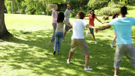 group of casual young friends playing ring a ring a rosie