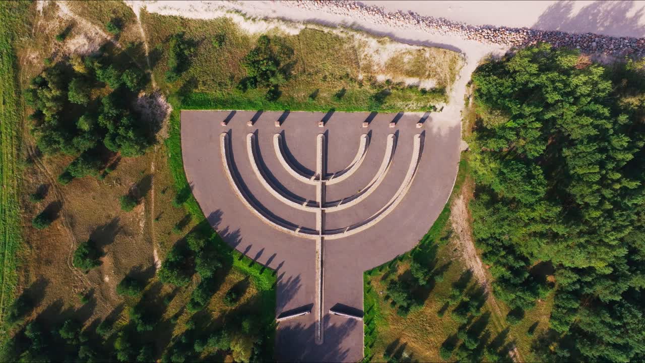 Aerial pullback shows symbolic monument blending nature history, Liepaja