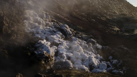 Vista-Panorámica-Lenta-A-La-Derecha-Del-Cráter-Eldvörp-Al-Atardecer-Con-Vapor-Y-Nieve-Ligera