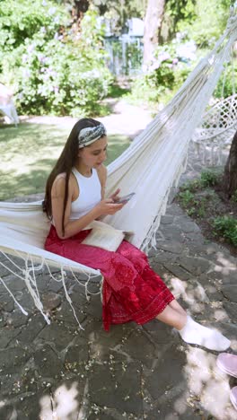 teenage girl relaxing in a garden hammock