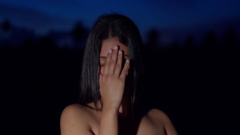 primer plano facial de una joven latina por la noche con un amanecer en el fondo